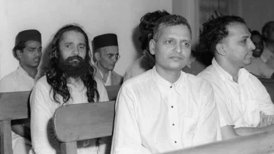 মহাত্মা গান্ধীকে হত্যার অভিযোগে অভিযুক্ত নাথুরাম গডসে ও নারায়ণ আপ্তের (সামনের সারি) বিচারিক আদালতে। ছবি: ভারত সরকার