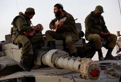 An Israeli soldier is singing while sitting on the battlefield.  Recently taken.  Photo: Reuters 