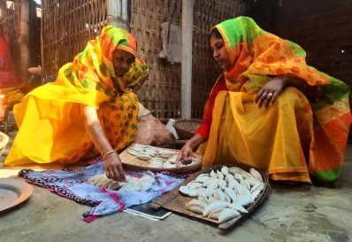 বাড়ির আঙিনায় গ্রামের নারীরা পিঠা বানাচ্ছেন। ছবি: সংগৃহীত