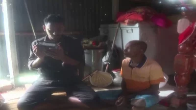 পরিবারের সদস্যদের নিয়ে রেডিওতে আবওয়ার শুনছেন এক যুবক। ছবি: ইনডিপেনডেন্ট টেলিভিশন 
