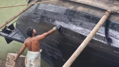 মাছ শিকারে যাওয়ার জন্য নৌকায় আলকাতরা দিচ্ছেন এক জেলে। ছবি: ইনডিপেনডেন্ট টেলিভিশন